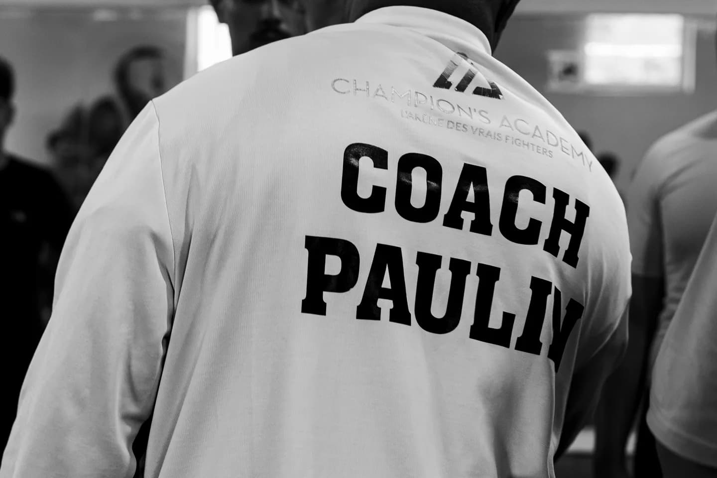 Veste de Champion’s Academy portant l’inscription Coach Paulin
