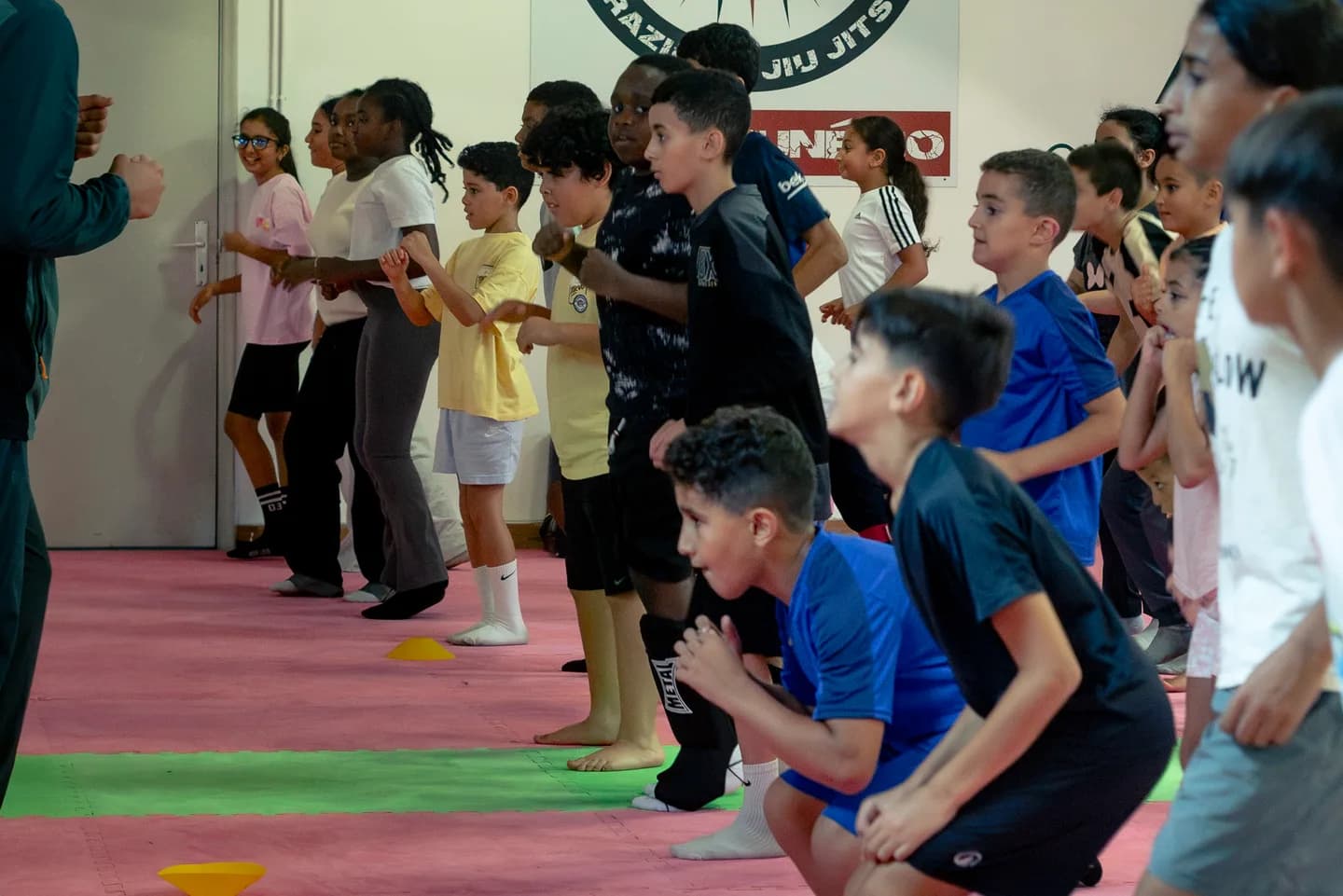 Groupe de jeunes à l’échauffement sur les tatamis de Champion’s Academy
